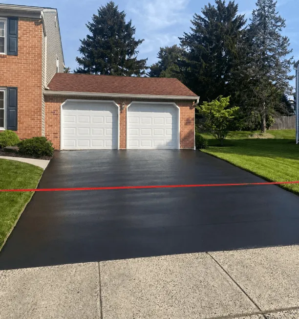Freshly sealcoated residential driveway with an even jet-black finish